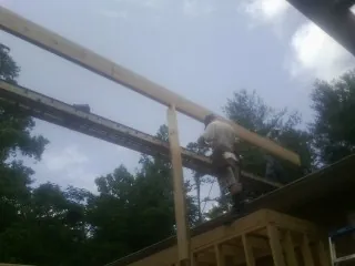 Carpenter setting a ridge beam over a new addition frame — Ice Dam Removal by Roofing Brothers in Yulan
